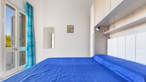 A bedroom with a bed, a window with curtains, a bedside table, and a wall-mounted lamp. - 2048 Casa Marchello - Bilo 2 by Barbarhouse (Castrignano del Capo)