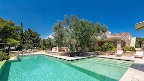 A rectangular swimming pool with clear blue water, surrounded by stone walls and trees. - 2457 Villa Allegra by Perle di Puglia (Castrignano del Capo)