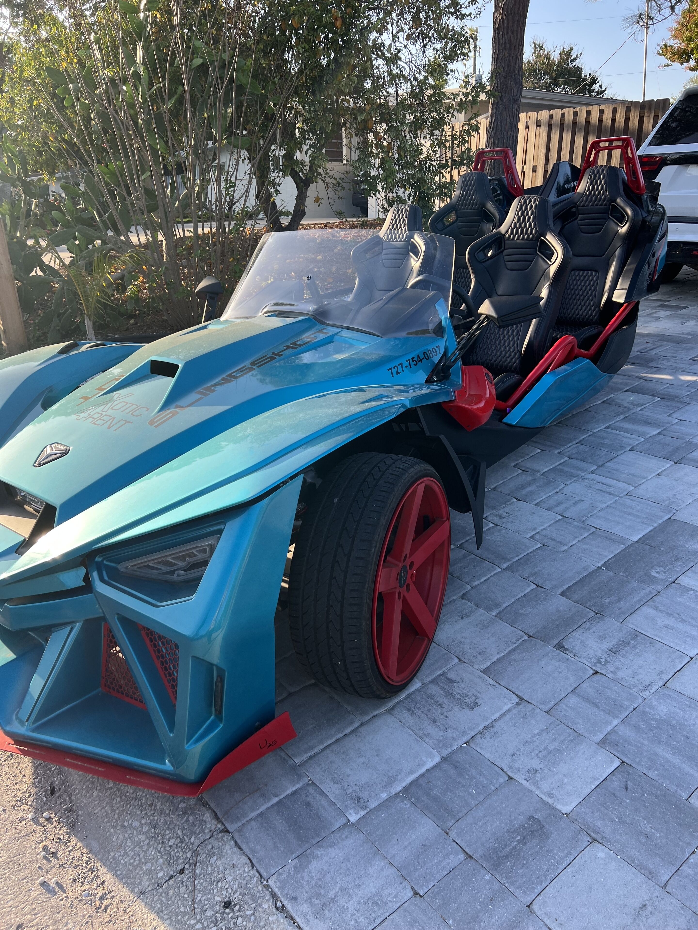 Un'auto sportiva futuristica parcheggiata su una superficie asfaltata.