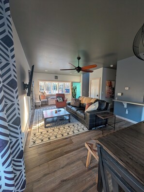 Un salón amplio con un sofá grande, una mesa de centro y una zona de comedor.
