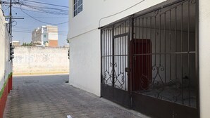 A narrow paved alleyway with a gated entrance to a building. - BEAUTIFUL APARTMENT WITH GREEN TERRACE (Cholula)