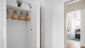 Un dressing avec des portants en bois et des serviettes blanches pliées.