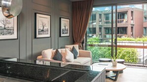 Una habitación de hotel moderna con un sofá, una mesa de centro y cuadros en la pared.