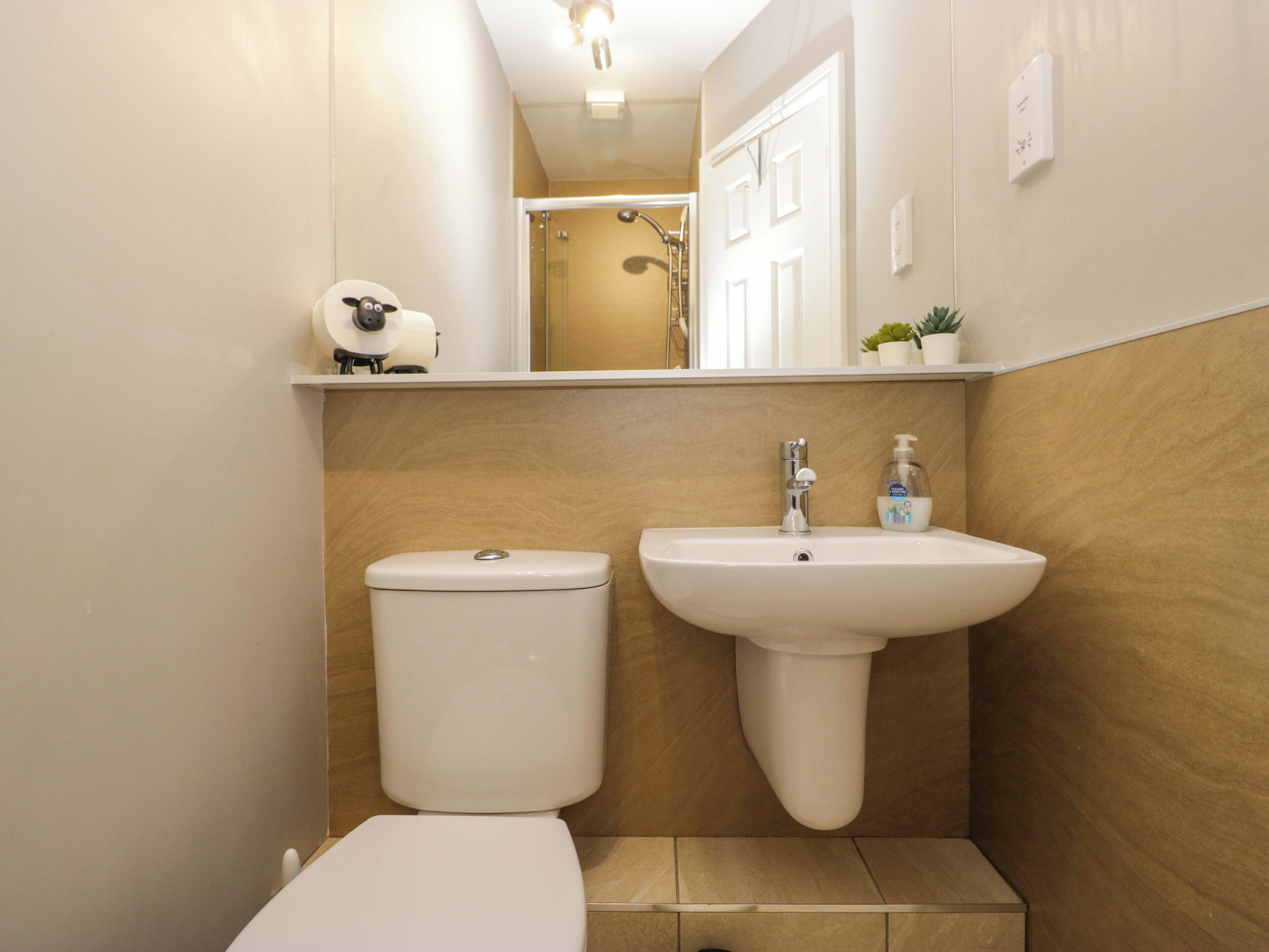 Ein kleines Badezimmer mit Toilette, Waschbecken und einem Ablagebereich für Toilettenartikel.