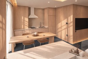 Una cocina moderna con estufa integrada, un lavamanos y un televisor de pantalla plana montado en la pared.