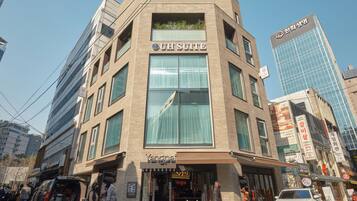 Un bâtiment moderne, avec une enseigne indiquant « UH SUITE » et un restaurant appelé « Yangpai » situé au rez-de-chaussée.