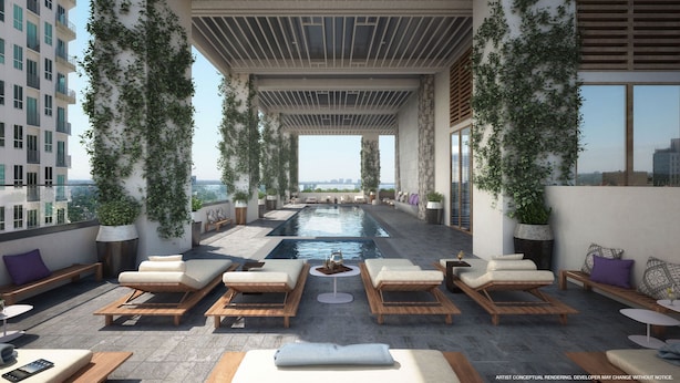 A rooftop pool area with lounge chairs and a central table, surrounded by greenery and overlooking a cityscape. - Modern High-Rise Condo with Pool/Gym, in Central DT MIAMI! (Miami)