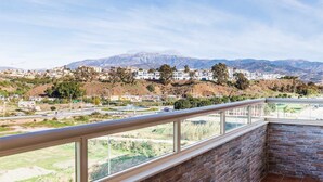 Un balcone con vista su una città e montagne.