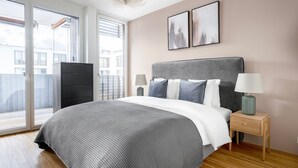 A bedroom with a bed, two bedside tables, a nightstand, a dresser, and a sliding glass door leading to a balcony. - Lux Wollishofen 2.5 Room w/ W/D & Storage, 2 min to Market, by Blueground (Zurich)