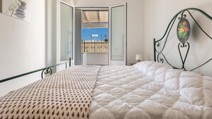 A bedroom with a bed, a window, and a view of the outside.