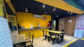 A restaurant with a yellow and black color scheme, featuring a counter, chairs, and a table. - Taipei Inn (Taipei)