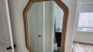 A white door with a rope-framed mirror.