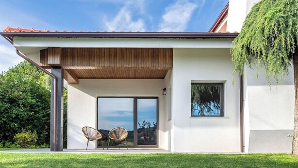 A modern house with a covered patio, large sliding glass doors, and a small window. - 6-bed House - Sleeps 12 - Pool, Bbq, Pool Table (Guimarães)