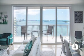 Relax on the balcony overlooking the water and city views, with comfortable seating and a convenient location.