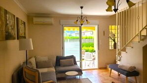 A living room with a sofa, armchairs, a small table, a bench, and a staircase. - Townhouse ALDEA DEL MAR with direct access to the swimming pool (Poblets (els))