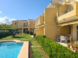 A residential building with a swimming pool, a well-maintained garden, and outdoor seating. - Townhouse ALDEA DEL MAR with direct access to the swimming pool (Poblets (els))