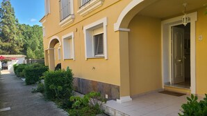A yellow building with white trim, a tiled entrance, and a door marked with the number 9. - Townhouse ALDEA DEL MAR with direct access to the swimming pool (Poblets (els))