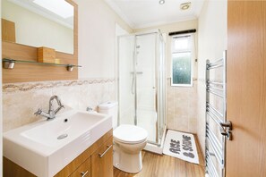 Une salle de bain moderne avec une douche à parois de verre, un lavabo blanc et des toilettes.