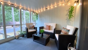 A cozy patio area with wicker furniture, string lights, and potted plants. - Welcoming, Roomy and Conveniently Located! (Hot Springs Village)