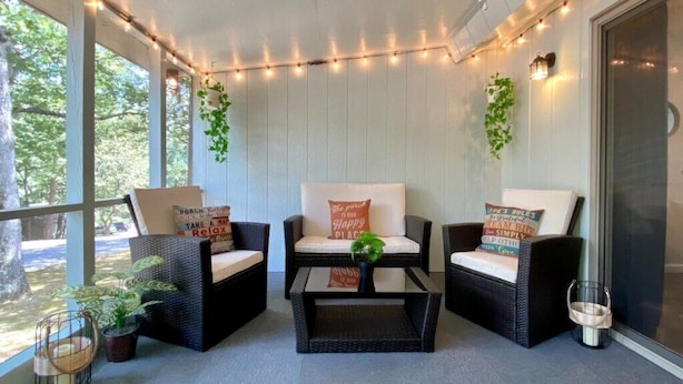 A covered porch with wicker furniture, string lights, and potted plants. - Welcoming, Roomy and Conveniently Located! (Hot Springs Village)
