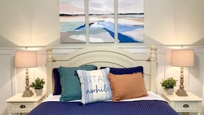 A bedroom with a large bed, two bedside tables with lamps, and a wall-mounted painting above the bed. - Welcoming, Roomy and Conveniently Located! (Hot Springs Village)