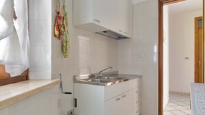 A compact kitchen with a sink, cabinets, and a countertop. - 2808 Case al Tacco - Appartamento Terra by Barbarhouse (Castrignano del Capo)