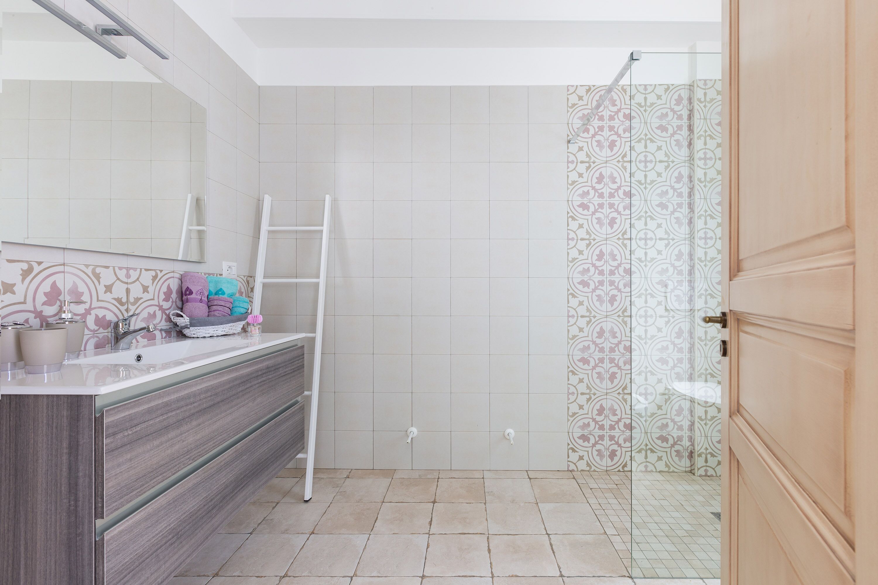 Un baño con tocador, espejo y zona de ducha.