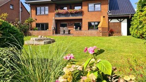 A two-story house with a balcony, a small garden, and a brick exterior. - Large time-out apartment - modern, close to the beach and with a large garden terrace - (Neustadt in Holstein)