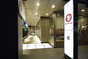 A hallway with a Travelodge sign, a reception area, and a view of the outside.