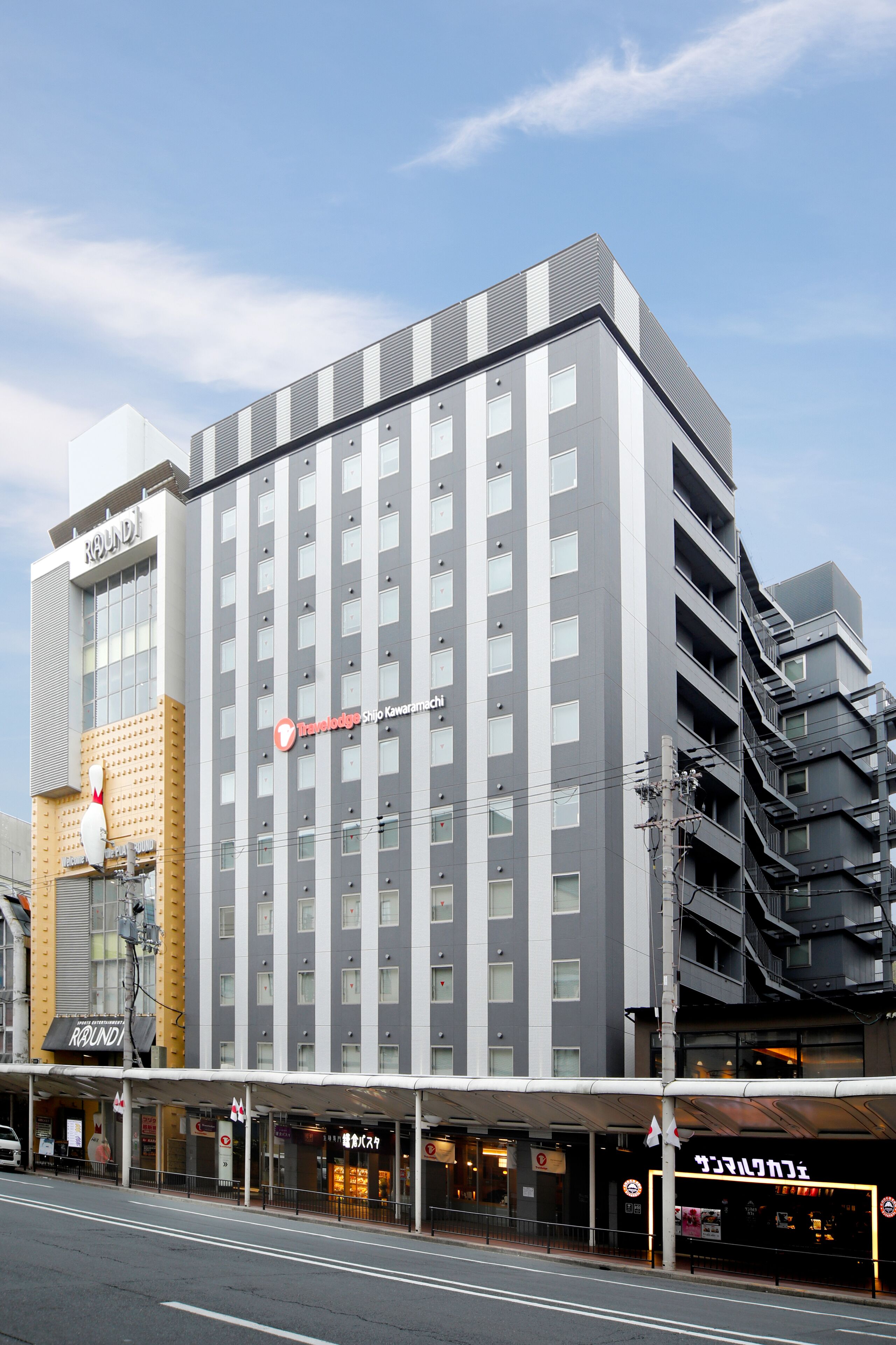 A multi-story hotel with a modern design, featuring a prominent sign and a covered entrance area.