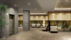 A modern lobby with a reception desk, seating area, and large windows with vertical blinds.
