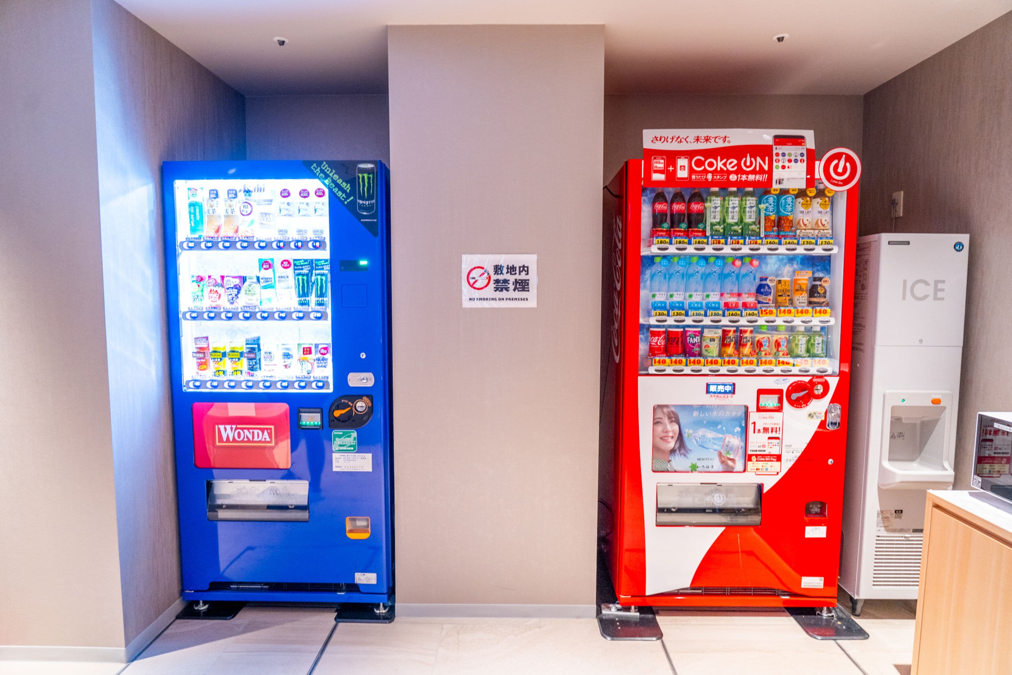 A vending machine area with a Wonda and a Coca-Cola machine, and an ICE refrigerator.