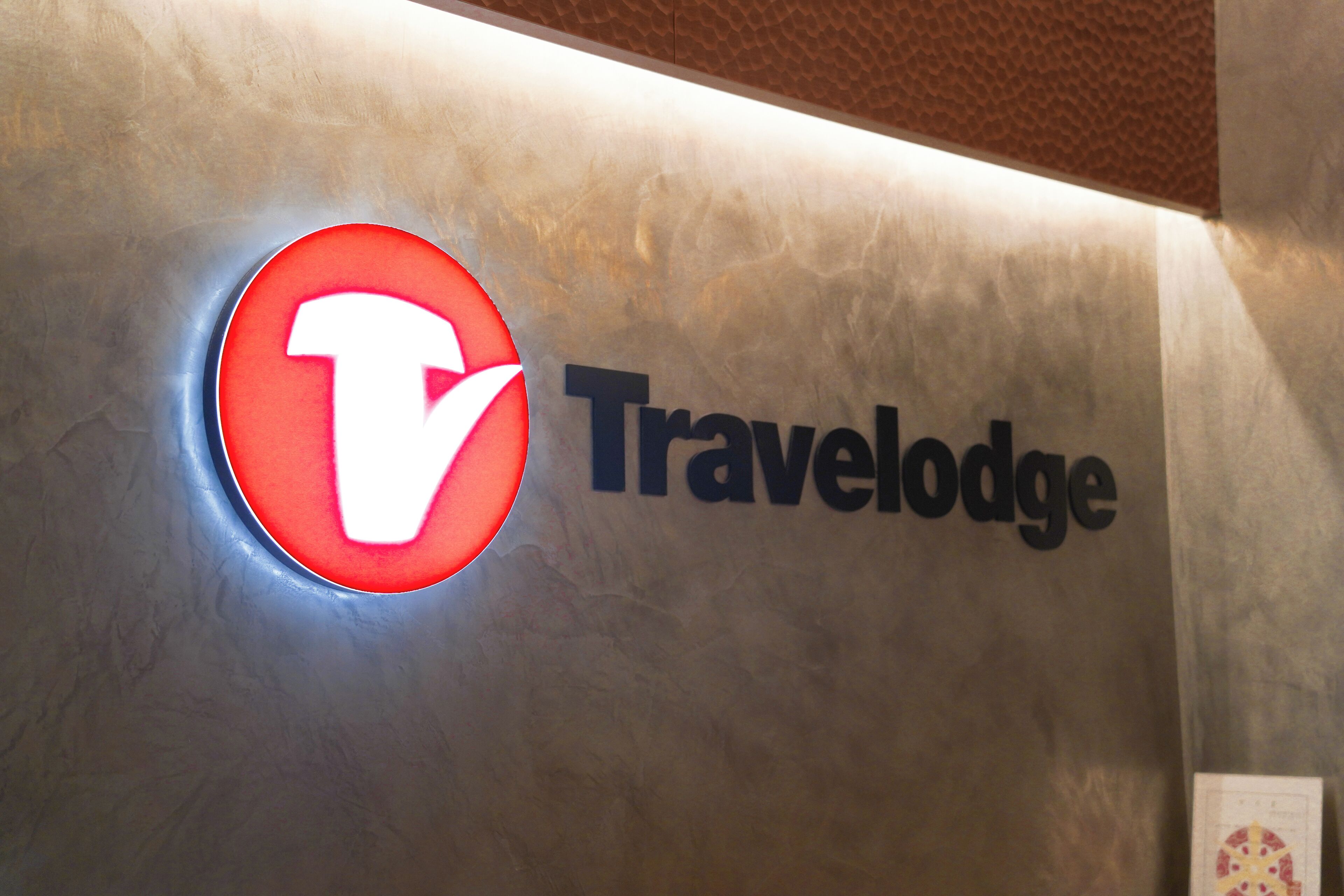 A wall with a logo and the word "Travelodge".