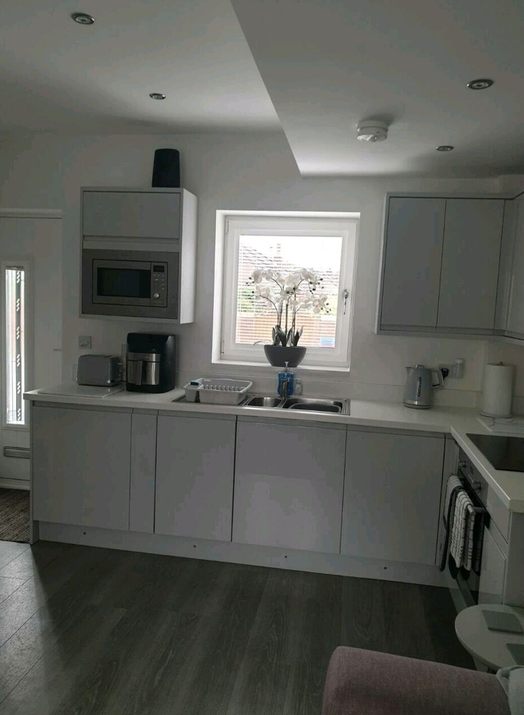 A modern kitchen with a central island, built-in microwave, and a window with a view.