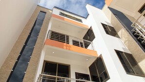 A modern building with a sign reading "Washington Court Apartments." - Executive Large Room With Ensuite (Accra)
