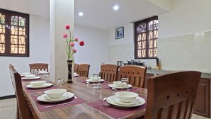 A dining area with a wooden table set for six, surrounded by chairs. - Villa Calangute Phase 2 (Calangute)