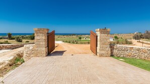 A paved entrance with stone walls and a clear view of the landscape beyond. - 2475 Villa Pietra del Sole by Perle di Puglia (Salve)