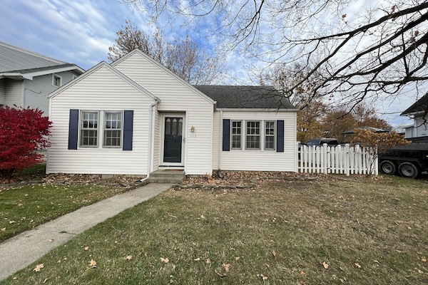 Front of the cottage with white picket fence on side yard.