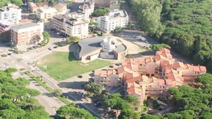 Vue aérienne d’un quartier résidentiel où se côtoient des bâtiments modernes et traditionnels, dont un imposant édifice circulaire surmonté d’un dôme.