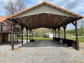A covered outdoor area with a gravel floor, wooden beams, and a metal roof. - 2 RV spots  full hookup, 30&50 amp sewer & water . In City limits of Sunbright (Sunbright)