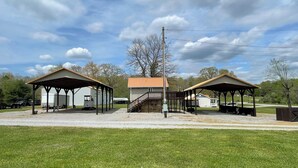 Área externa coberta com dois edifícios, uma escadaria e um campo gramado.