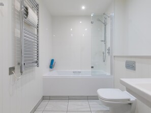 A modern bathroom with a glass-enclosed shower, a white bathtub, and a toilet.