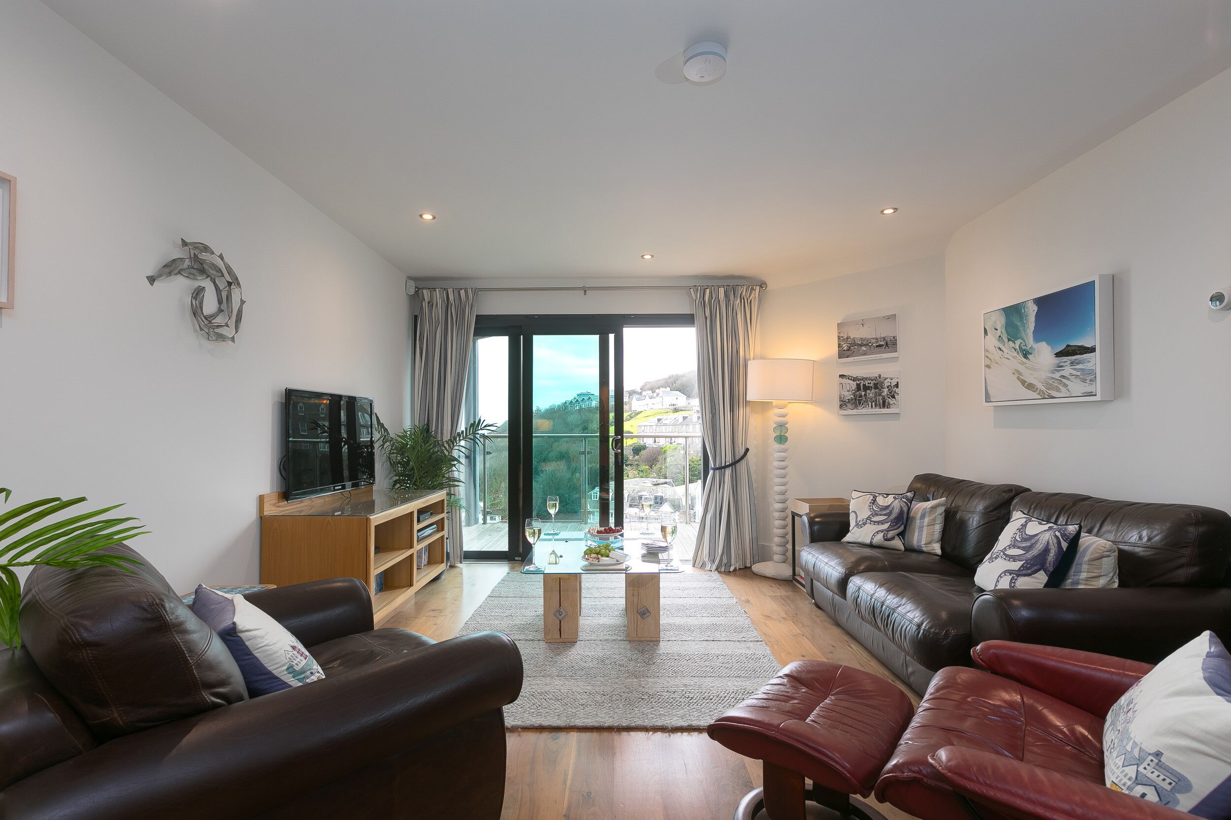 A modern living room with leather sofas, a wooden coffee table, and a television.