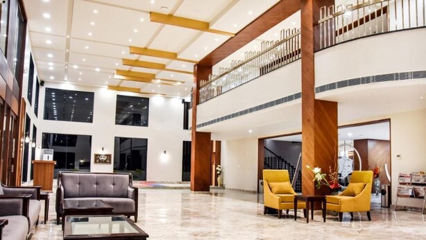A spacious lobby with a high ceiling, a staircase, and seating areas. - Hotel Platinum Shravasti (Ikauna)