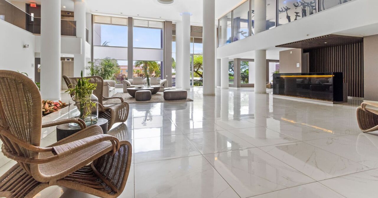 A spacious lobby with high ceilings, a reception desk, and seating areas.
