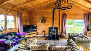 A cozy log cabin interior with a television, a fireplace, and comfortable seating. - Sleeps6- Hot Tub- Pet Friendly- Log Burner (York)
