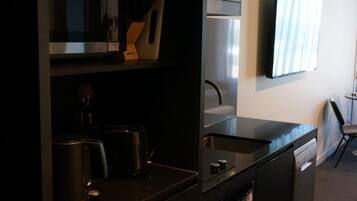 A modern kitchen with a coffee maker, a microwave, and a dishwasher.