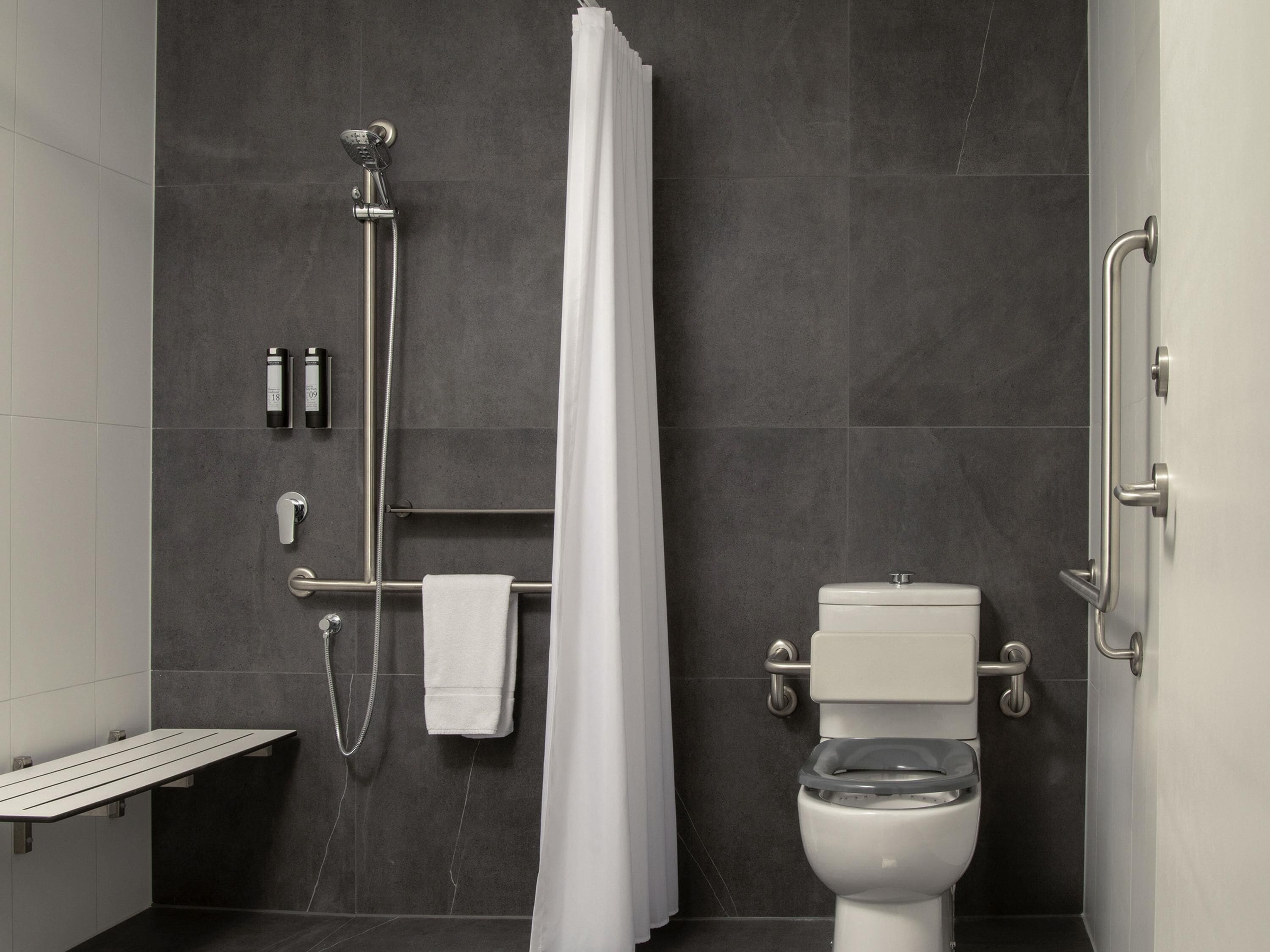 A modern bathroom with a shower, toilet, and a towel rack.