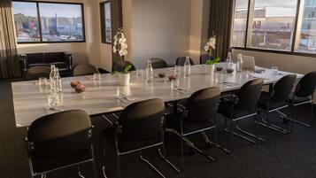 A conference room with a long table, chairs, and a laptop.