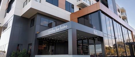 Un edificio moderno con un restaurante llamado 'tonsley bar bistro' en la planta baja.